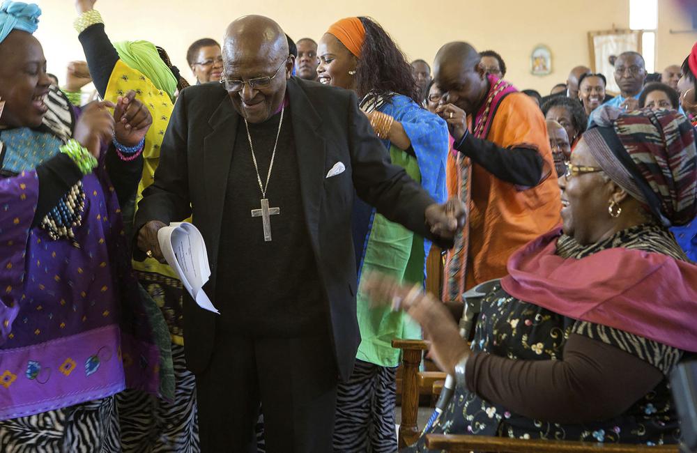 FILE - Anglican Archbishop Emeritus Desmond Tutu, center, breaks into dance after renewing his wedding vows to his wife of 60 years, Leah, right, during a service in Soweto, Johannesburg, Aug. 2015. Tutu, South Africa’s Nobel Peace Prize-winning activist for racial justice and LGBT rights and retired Anglican Archbishop of Cape Town, has died, South African President Cyril Ramaphosa announced Sunday Dec. 26, 2021. He was 90. (AP Photo, File)